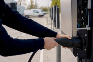 Techniker schließt Kabel an Ladestation für Elektrofahrzeuge an
